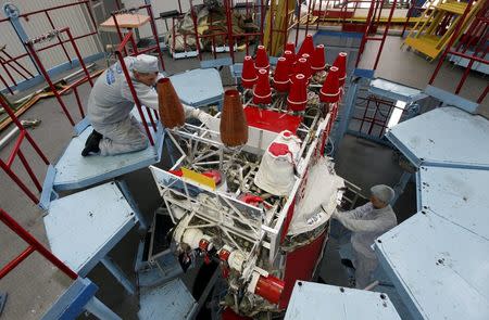 Fitters of space apparatus work on the GLONASS-M space navigation satellite inside an assembly workshop of the Reshetnev Information Satellite Systems company in the Siberian town of Zheleznogorsk, some 50 km (31 miles) northeast of Krasnoyarsk, April 2, 2014. REUTERS/Ilya Naymushin/File Photo