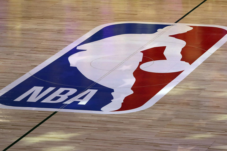 FILE - An NBA logo is seen at center court prior to an NBA basketball game between the Los Angeles Clippers and the Los Angeles Lakers, Thursday, July 30, 2020, in Lake Buena Vista, Fla. The NBA has agreed to terms on its new media deal, an 11-year agreement worth $76 billion that assures player salaries will continue rising for the foreseeable future and one that will surely change how some viewers access the game for years to come. (Mike Ehrmann/Getty Images via AP, Pool, File)