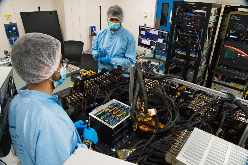 Mahmood al-Nasser, left, and Mohammad Nasser al-Emadi, center, test the Emirates Mars Mission probe's "flat sat" at the Mohammed bin Rashid Space Center in Dubai, United Arab Emirates on Thursday, June 25, 2020. The spacecraft, named Amal, which is Arabic for Hope, is an orbiter scheduled to launch from Japan in July 2020, on what will be the Arab world’s first interplanetary mission. It is scheduled to arrive at Mars in 2021, the year the UAE marks the 50th anniversary of its founding. (AP Photo/Jon Gambrell)