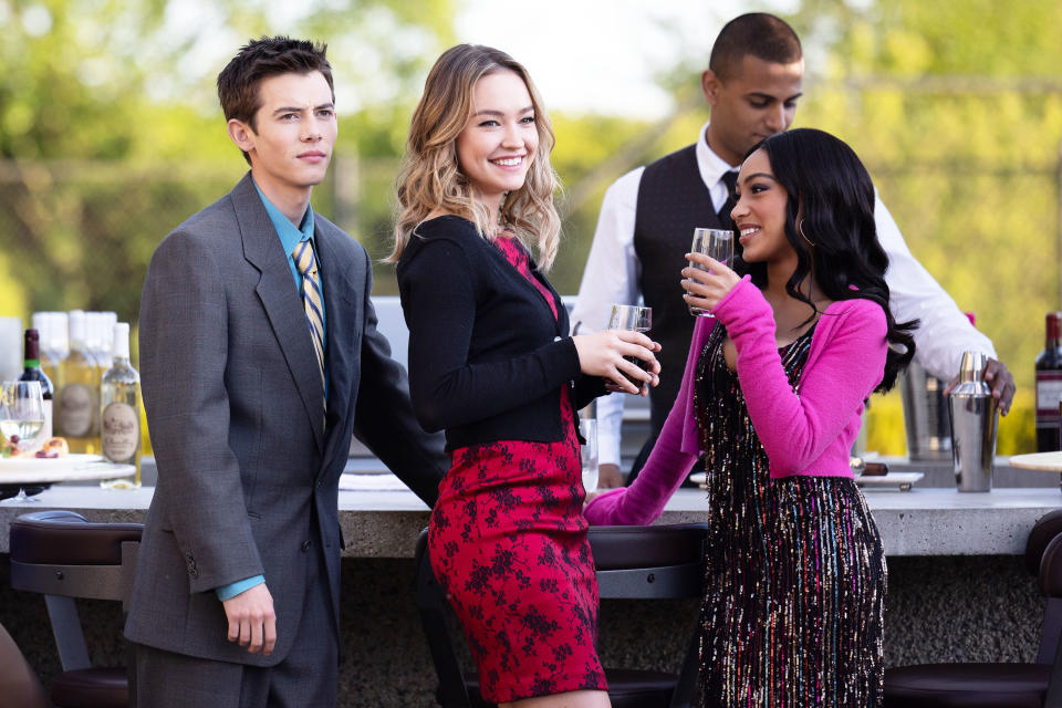 Three young people smiling at an open bar