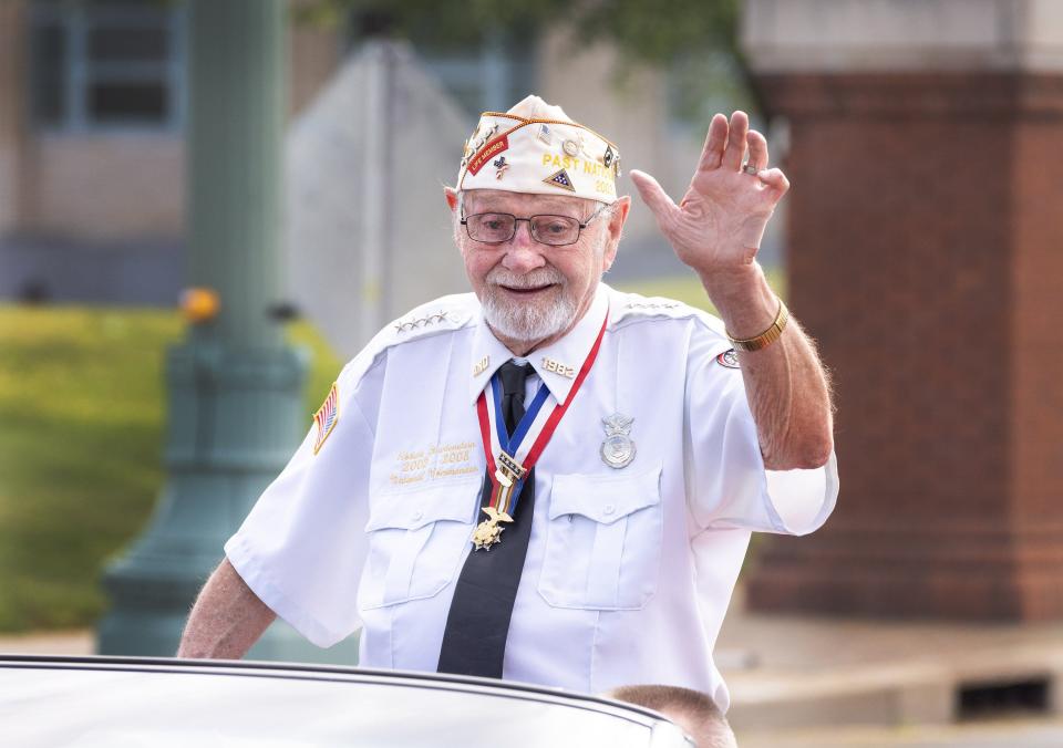 Veteran Robert Hartenstein waves to the crowd at Canton’s Memorial Day parade Monday.