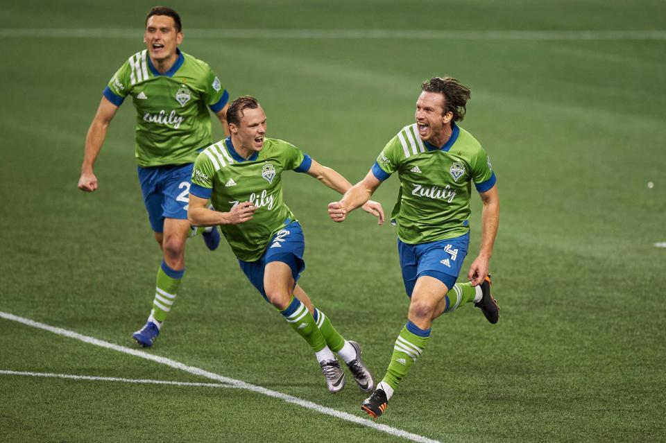 The Seattle Sounders' Gustav Svensson (4) celebrates with teammate Brad Smith (2) after scoring the winning goal against Minnesota United.