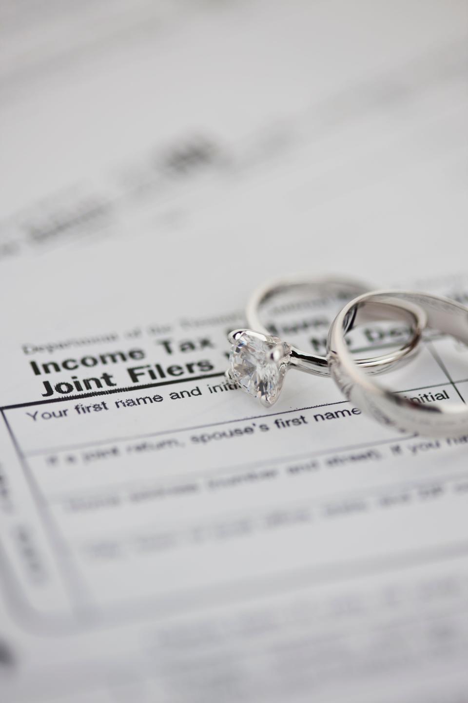 Tax forms with wedding rings.