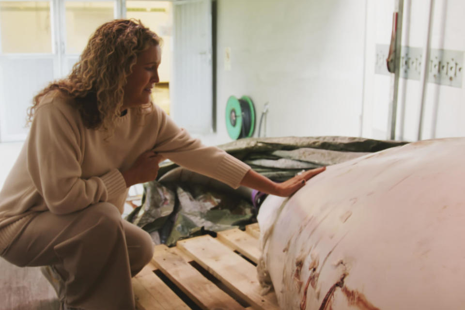 This photo provided by OneWhale.org on Wednesday, Sept. 4, 2024, shows manager Regina Haug next to the carcass of the beluga whale Hvaldimir, who was found dead on Saturday, Aug. 31, 2024. / Credit: OneWhale.org / AP