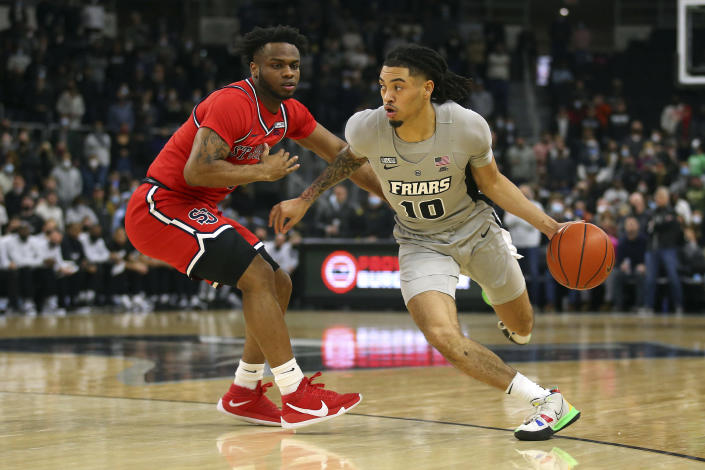 Providence's Alyn Breed (10) drives to the basket as St. John's Posh Alexander (0) defends during the first half of an NCAA basketball game on Saturday, Jan. 8, 2022, in Providence, R.I. (AP Photo/Stew Milne)