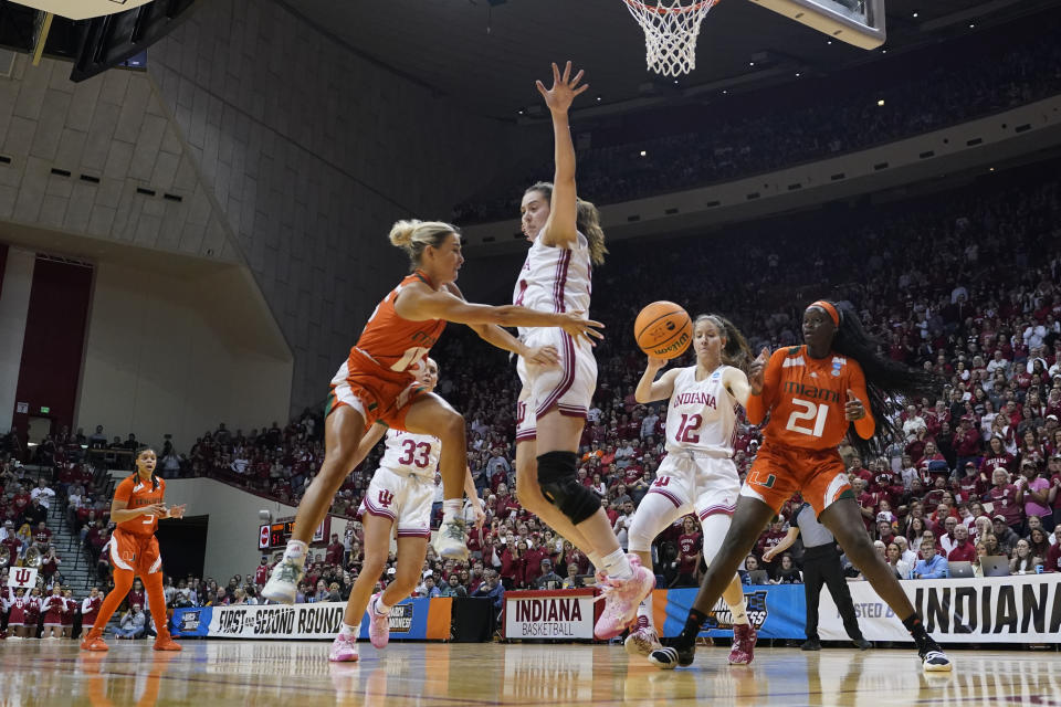 Miami's Hanna Cavinder (15) makes a pass against Indiana's Mackenzie Holmes (54) during the second half of a second-round college basketball game in the women's NCAA Tournament Monday, March 20, 2023, in Bloomington, Ind. (AP Photo/Darron Cummings)