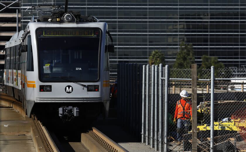 LOS ANGELES-CA-JANUARY 22, 2018: A Green Line train leaves the Aviation/LAX Station in Los Angeles on Monday, January 22, 2018 as work is underway, at right, for the future Crenshaw/LAX line. Five Green Line stations will close to allow Green Line tracks to be connected to the future Crenshaw/LAX line beginning January 26 and continuing through Saturday, April 7. Free Metro bus service will replace rail service at Aviation/LAX, Mariposa, El Segundo, Douglas and Redondo Beach stations. (Christina House / Los Angeles Times)