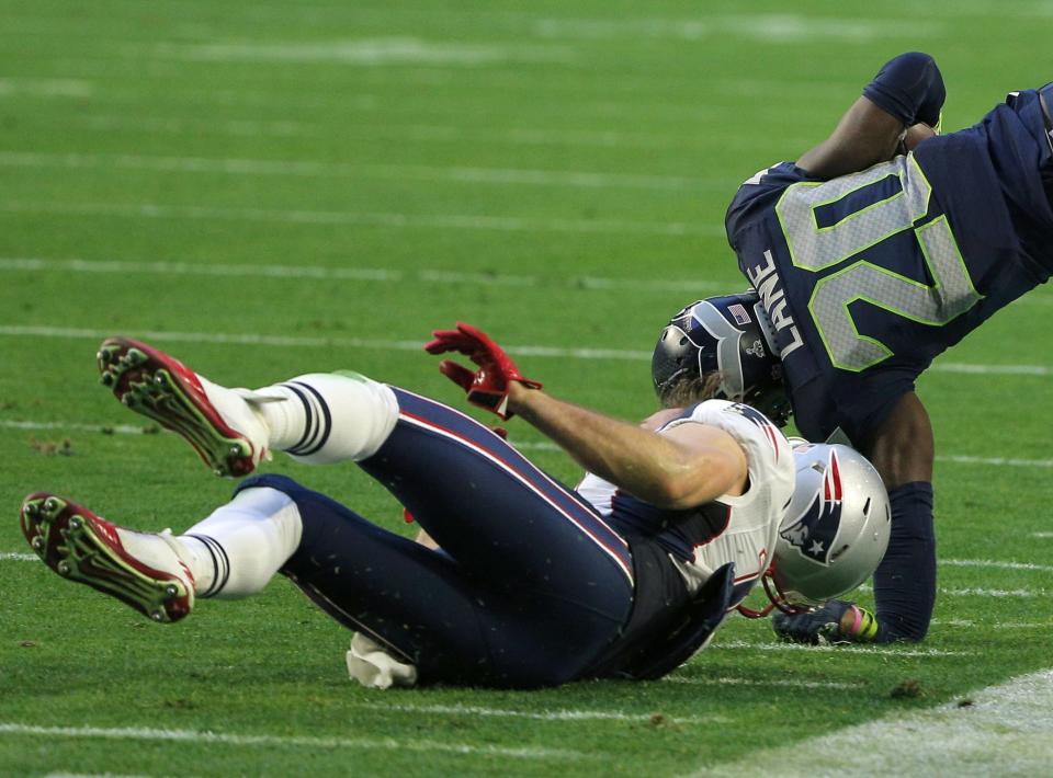 Seattle Seahawks cornerback Lane is tackled by New England Patriots wide receiver Edelman after making a first quarter interception during the NFL Super Bowl XLIX football game in Glendale