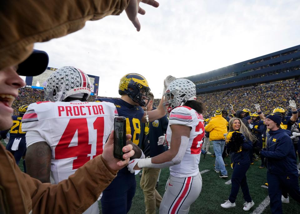 Nov. 25, 2023; Ann Arbor, Mi., USA;
Michigan Wolverines tight end Colston Loveland (18) and Ohio State Buckeyes linebacker Steele Chambers (22) meet on the field as Wolverine fans celebrate a 20-24 win following SaturdayÕs NCAA Division I football game at Michigan Stadium.