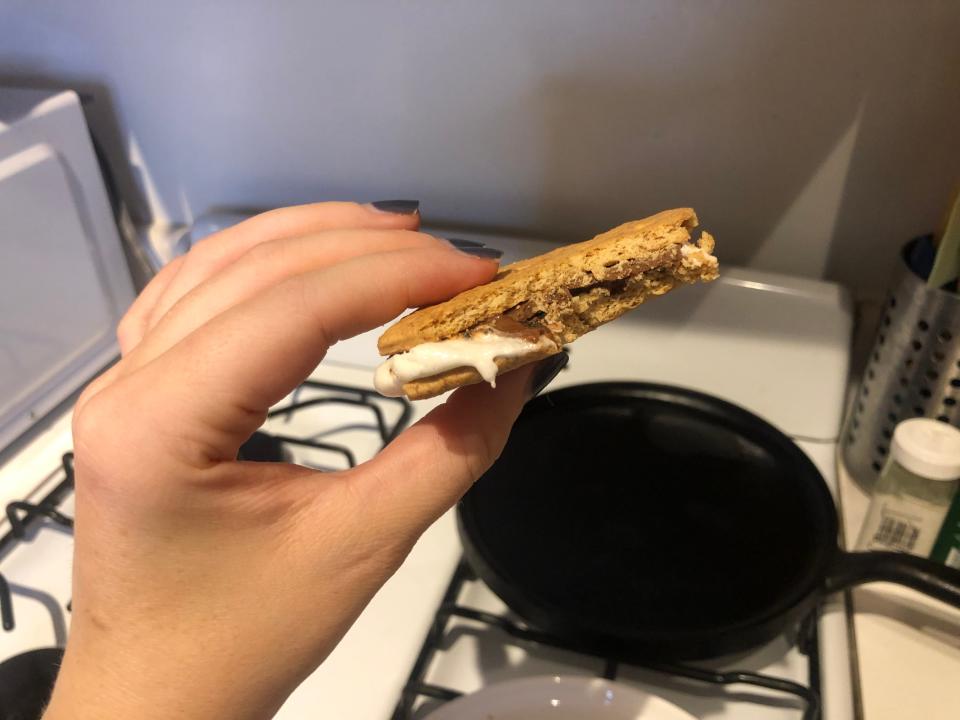 hand holding smore over a gas stove