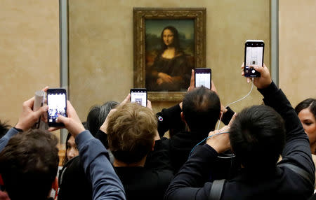 FILE PHOTO: Visitors take pictures of the painting "Mona Lisa" (La Joconde) by Leonardo Da Vinci at the Louvre museum in Paris, France, December 3, 2018. REUTERS/Charles Platiau/File Photo