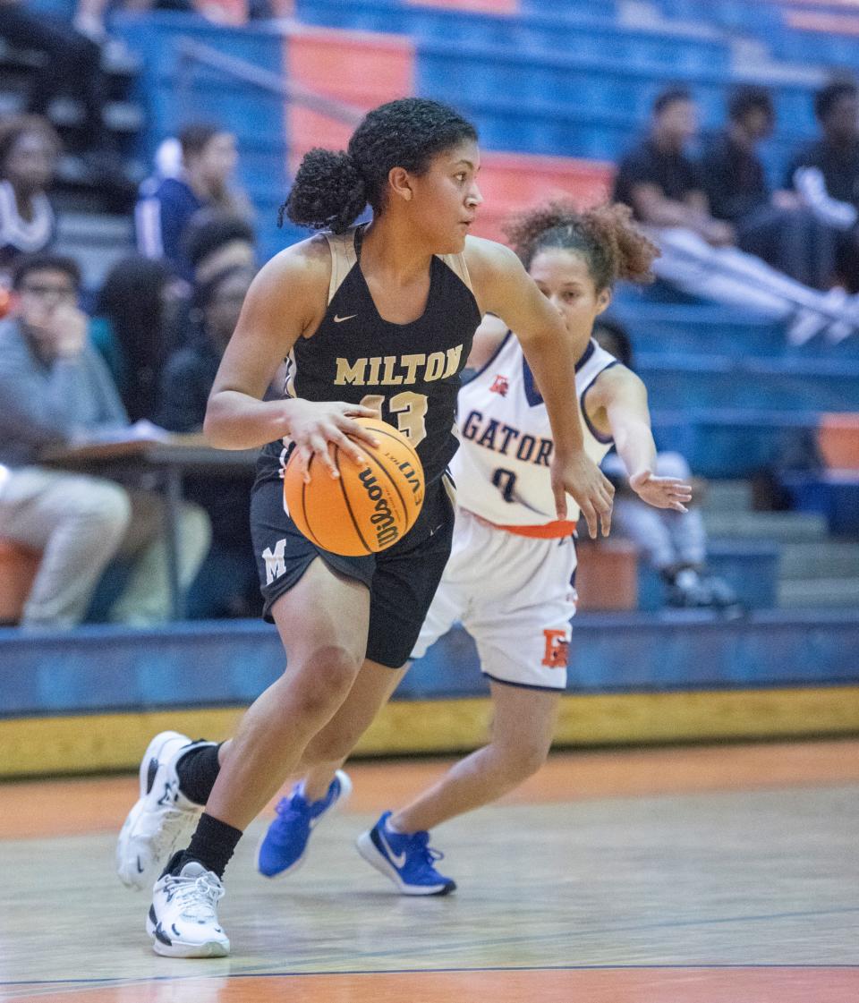 Laila  Manning (13) drives past (0) during the Milton v Escambia girls basketball game at Escambia High School in Pensacola on Thursday, Jan. 6, 2022.