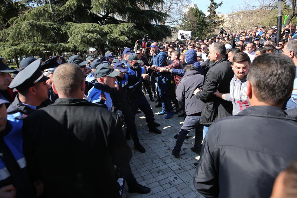Protesters scuffle with police guarding the parliament building as thousands of opposition supporter try to storm in during a protest in Tirana, Albania on Saturday, March 16, 2019. Albanian opposition supporters clashed with police while trying to storm the parliament building Saturday in a protest against the government which they accuse of being corrupt and linked to organized crime.(AP Photo/Visar Kryeziu)