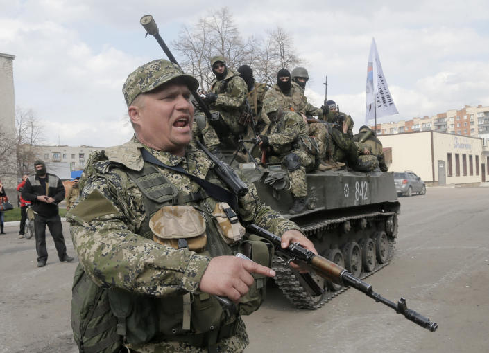 FILE - A pro-Russian separatist clears the way for a combat vehicle in Slovyansk, Ukraine, Wednesday, April 16, 2014. The eastern Ukrainian city of Slovyansk was occupied by pro-Russian separatists for months in 2014. Now its people are preparing to defend their community again as the fighting draws closer and invites a major battle. Slovyansk is a city of splintered loyalties, with some residents antagonistic toward Kyiv or nostalgic for their Soviet past. (AP Photo/Efrem Lukatsky, File)