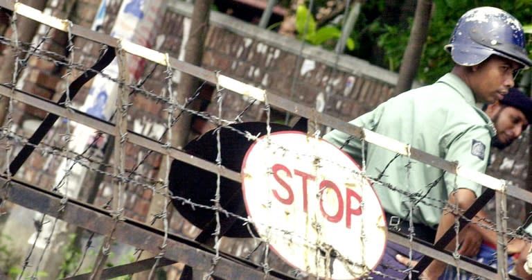 Bangladeshi police stand guard behind a barricade near the diplomatic zone in Dhaka in 2005