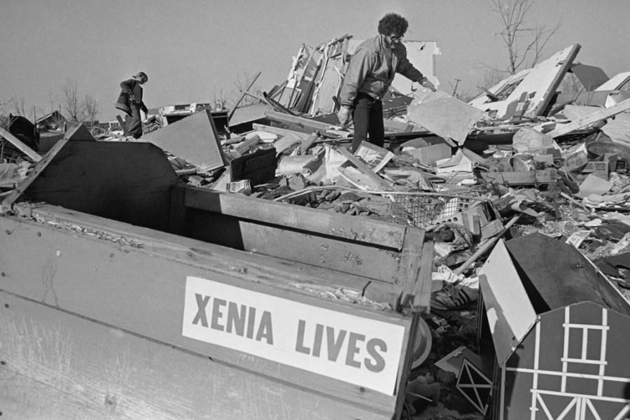 FILE – Amid the ruins and battered possessions of a home lies a wrecked dog house bearing a “Xenia Lives” sticker on April 18, 1974, in Xenia, Ohio, distributed by a local church on Easter Sunday. Manny Kazee, background, helps in the cleanup of a neighbor’s home in the Ohio town devastated by the tornado of April 3. The deadly tornado killed 32 people, injured hundreds and leveled half the city of 25,000. Nearby Wilberforce was also hit hard. As the Watergate scandal unfolded in Washington, President Richard Nixon made an unannounced visit to Xenia to tour the damage. Xenia’s was the deadliest and most powerful tornado of the 1974 Super Outbreak.(AP Photo/Steve Pyle, file)