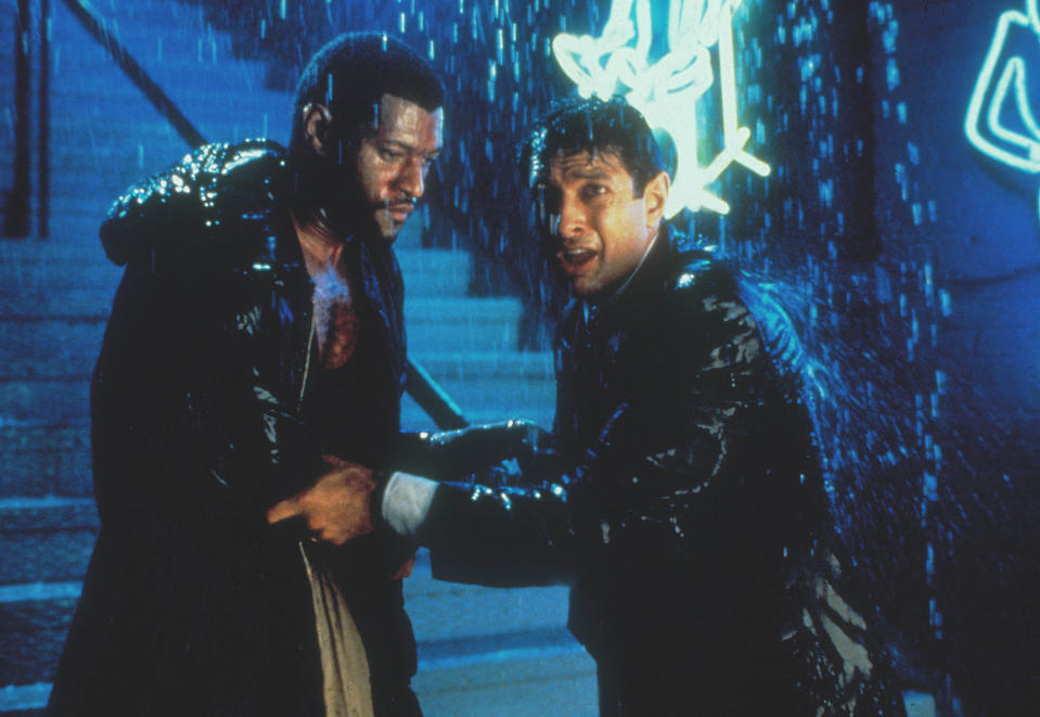 Laurence Fishburne and Jeff Goldblum stand in shock in the rain near a stairwell