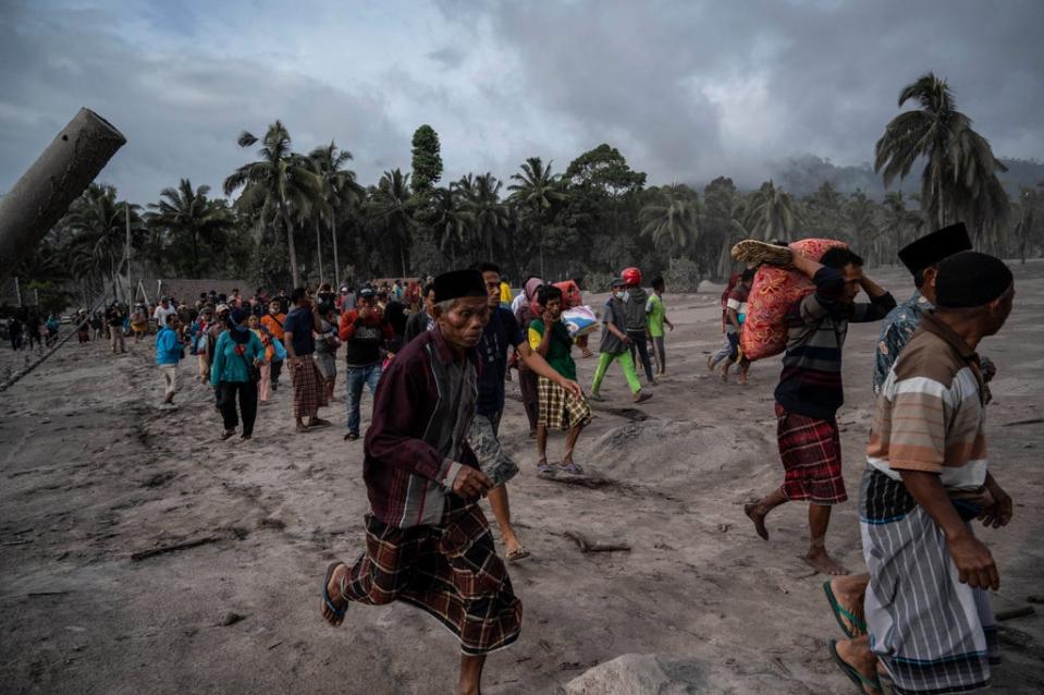 Villagers salvage their belongings in an area covered in volcanic ash at Sumber Wuluh village in Lumajang  (Getty Images)