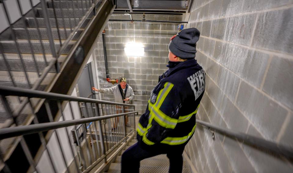 Providence fire inspector Jacqueline Davis shows construction manager Wayne Smith where to place exit signs in the stairwell at a new storage facility.