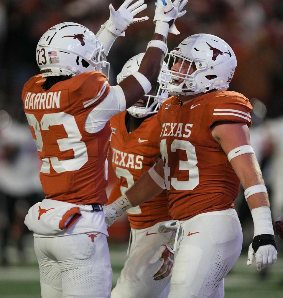 Teammates congratulate senior linebacker Jett Bush after he scored on a 43-yard interception return during Texas' 57-7 win over Texas Tech on Friday at Royal-Memorial Stadium. The Longhorns will play either Oklahoma State or Oklahoma in next Saturday's Big 12 championship game.
