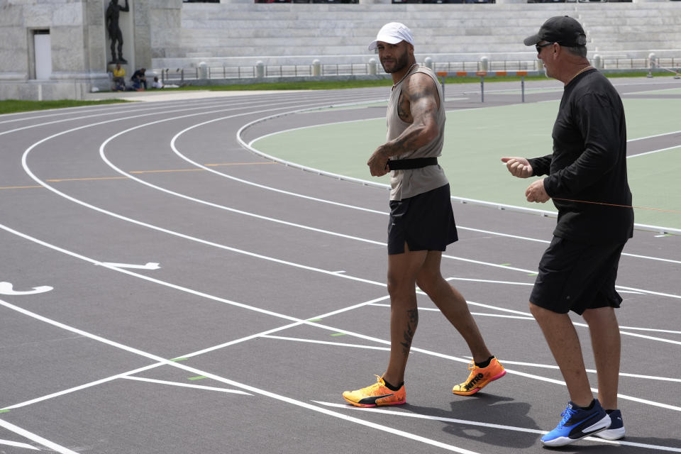 Defending Olympic 100 meters champion Marcell Jacobs, left, talks with his coach Rana Reider during a training session in the historic Stadio dei Marmi ahead of an athletics meeting in Rome, Wednesday, May 15, 2024. (AP Photo/Alessandra Tarantino)