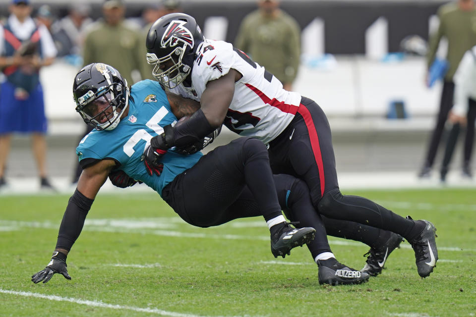 Jacksonville Jaguars running back James Robinson, left, is stopped by Atlanta Falcons linebacker Foyesade Oluokun during the first half of an NFL football game, Sunday, Nov. 28, 2021, in Jacksonville, Fla. (AP Photo/Chris O'Meara)