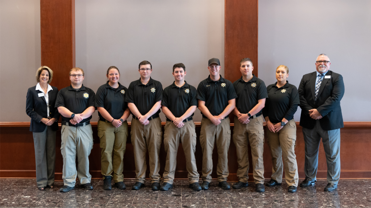 The graduates of Blue Ridge Community College's Detention Officer Certification Course (DOCC) stand together for a photo following the July 7 graduation ceremony. The graduates are flanked by College President Dr. Laura Leatherwood, left, and DOCC School Director David Hensley, right.