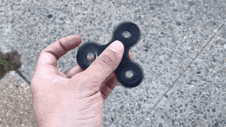fidget spinner spins in a person's hand