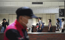 Face-masked people through the main train station in Tokyo, Japan on Saturday, July 31, 2021. (AP Photo/Kantaro Komiya)