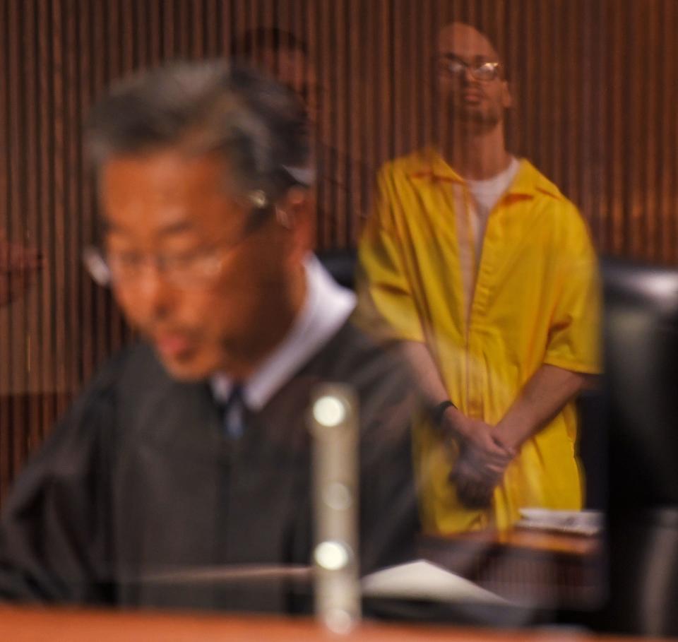 Sergio Correa, reflected in the courtroom plexiglass, listens as Judge Hunchu Kwak hands down a sentence of life without possibility of parole, plus 105 years, in New London Superior Court Tuesday, May 3, 2022. Correa was convicted in December on 13 of 14 counts in the murder of Kenneth, Janet, and Matthew Lindquist in Griswold in December of 2017.