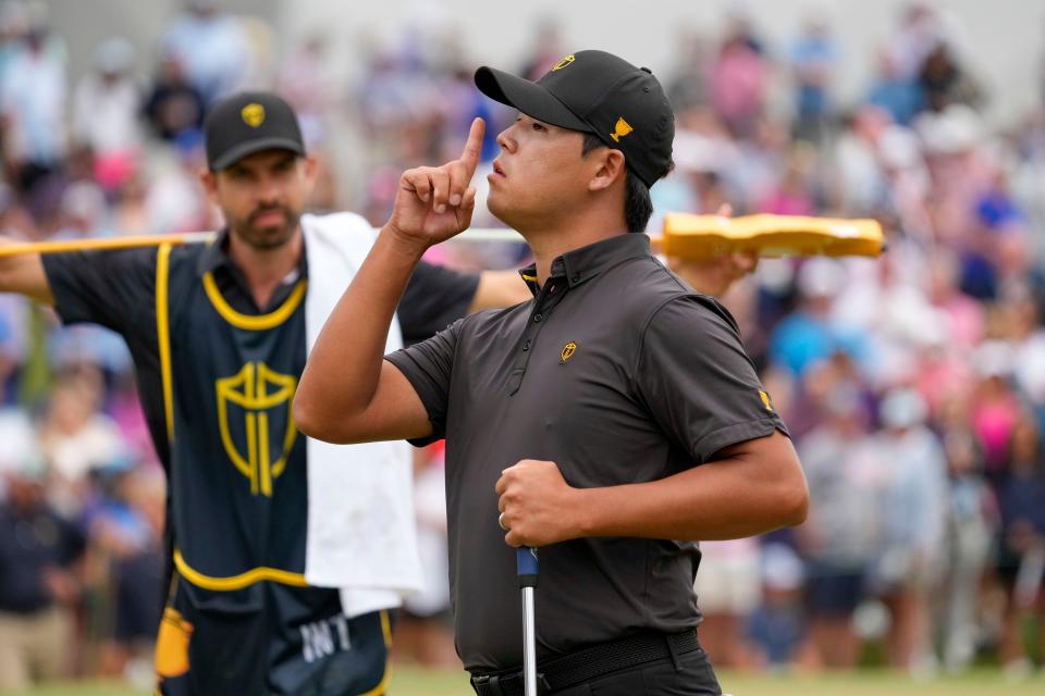 Si Woo Kim gestures to the crowd on Sunday after making a par putt at the 15th hole at Quail Hollow in his Presidents Cup singles match against Justin Thomas.