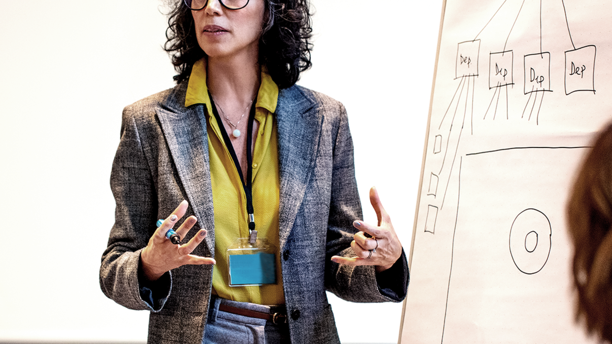 Businesswoman in menopause wearing suit and giving a presentation.