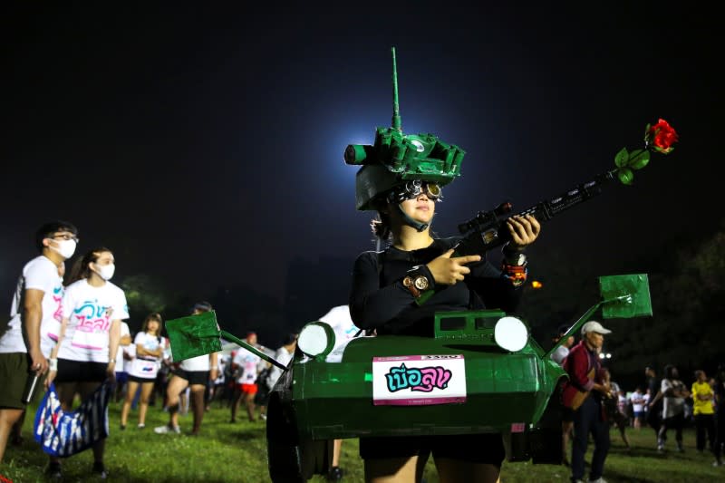 A runner dressed in a tank costume takes part in the "Run Against Dictatorship" event at a public park in Bangkok