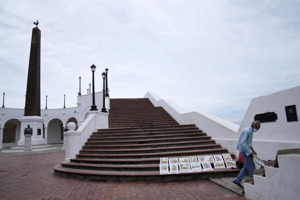 Un artista callejero coloca sus obras en las escaleras vacías de la Plaza de Francia en la zona del Casco Antiguo de la Ciudad de Panamá, el lunes 7 de junio de 2021, en medio de la pandemia de COVID-19. (AP Foto/Arnulfo Franco)