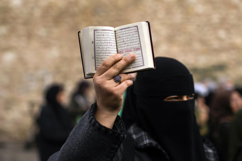 FILE - A woman holds up a Quran during a protest outside the Swedish consulate in Istanbul, Turkey, on Jan. 22, 2023. Turkish President Recep Tayyip Erdogan's abrupt approval of Sweden's NATO bid came after a year of objections to Stockholm to joining the defense alliance. (AP Photo/Francisco Seco, File)