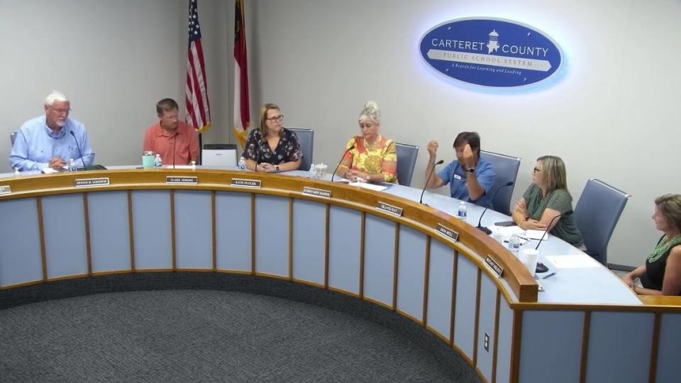 Carteret County School Board member Travis Day raises his hands to make the money gesture during the June 13, 2024, meeting as he accuses the tourism industry of blocking changes to North Carolina's school calendar law