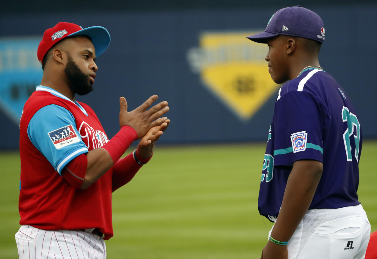 Primera base de los Philadelphia, Carlos Santana, a la izquierda, conversa con Ronald Vizcaíno, de España, antes del encuentro de los New York Mets, en el Clásico de Béisbol de Ligas Menores. / Foto: AP