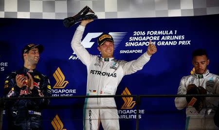 Formula One - F1 - Singapore Grand Prix - Marina Bay, Singapore- 18/9/16 Mercedes' Nico Rosberg of Germany celebrates winning the race as Mercedes' Lewis Hamilton of Britain and Red Bull's Daniel Ricciardo of Australia look on. REUTERS/Jeremy Lee