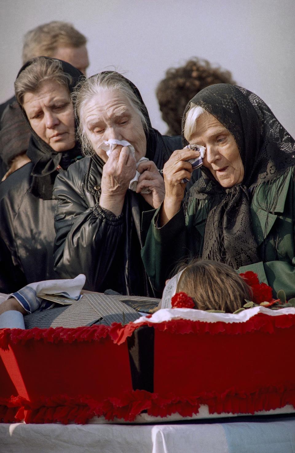 FILE - Relatives of Viktor Gogolev, 26, a civilian killed by a stray bullet near the Russian parliament building, the White House on Monday, cry as they pay their last respects at the Khovanskoe cemetery in Moscow's suburbs, on Oct. 8, 1993. The October 1993 violent showdown between the Kremlin and supporters of the rebellious parliament marked a watershed in Russia's post-Soviet history. (AP Photo/Alexander Zemlianichenko, File)