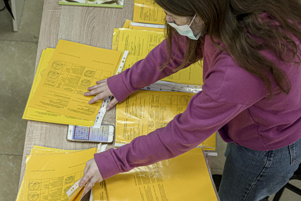 An employee prepares vaccination certificates at vaccination center center in Dnipro, Dnipropetrovsk region, Ukraine, Tuesday, Oct.19, 2021. Ukraine is suffering through a surge in coronavirus infections, along with other parts of Eastern Europe and Russia. While vaccines are plentiful, there is a widespread reluctance to get them in many countries — though notable exceptions include the Baltic nations, Poland, the Czech Republic, Slovenia and Hungary. (AP Photo/Evgeniy Maloletka)