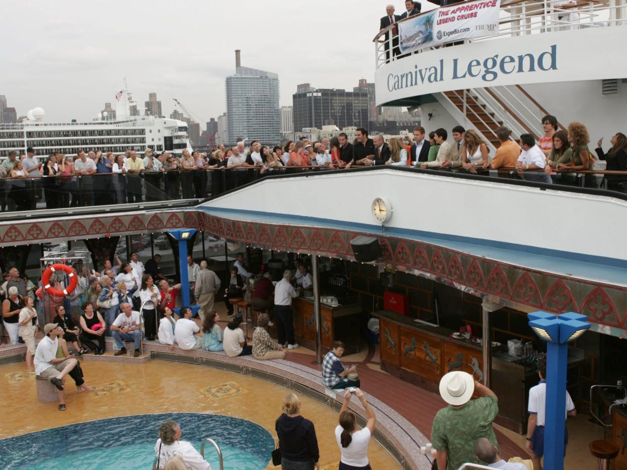 Crowds of people on different levels of a Carnival cruise ship.