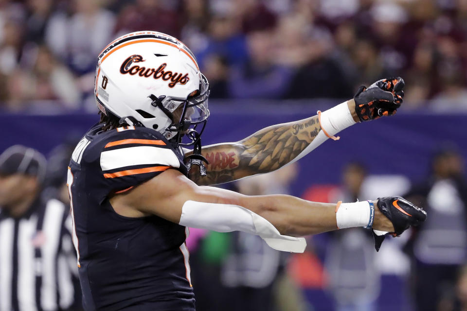 Oklahoma State running back Ollie Gordon II gestures to Texas A&M fans in the stands as he celebrates his touchdown during the first half of the Texas Bowl NCAA college football game Wednesday, Dec. 27, 2023, in Houston. (AP Photo/Michael Wyke)