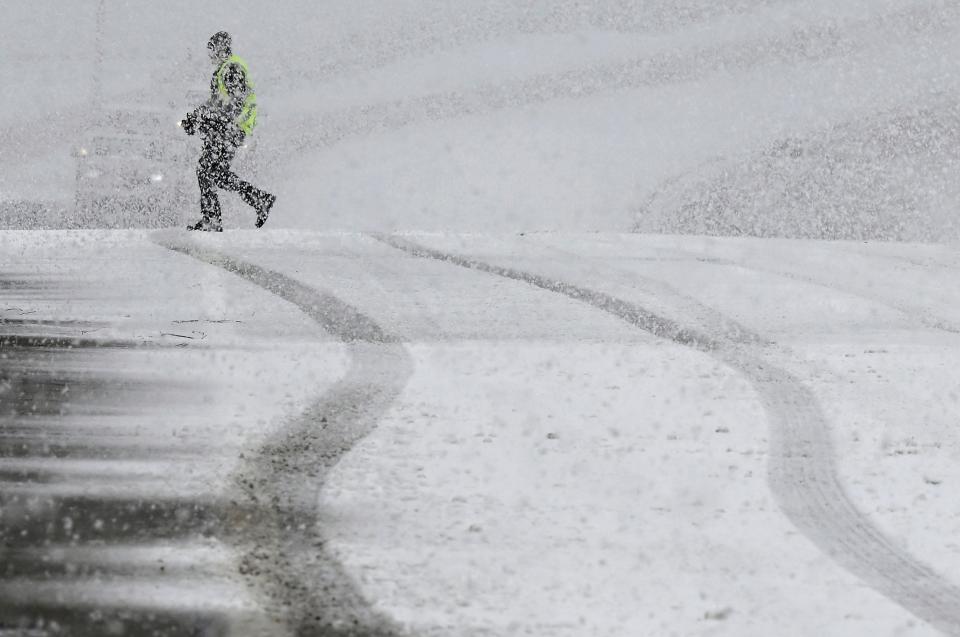A pedestrian walks across the Highway 38 overpass above I-15 in the California Cajon Pass on Thursday, Feb. 23, 2023 as heavy snow falls. The storm cell moved quickly through the area though more snow is in the forecast. (Will Lester/The Orange County Register via AP)