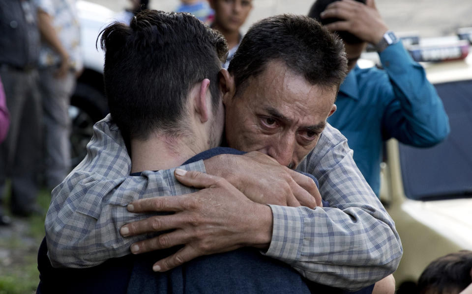 Un hombre abarza a su hijo, que acaba de ser deportado por EEUU, frente a la Dirección de Atención al Migrante de San Salvador. Todos los días llegan autobuses con personas deportadas. (AP Photo/Eduardo Verdugo)