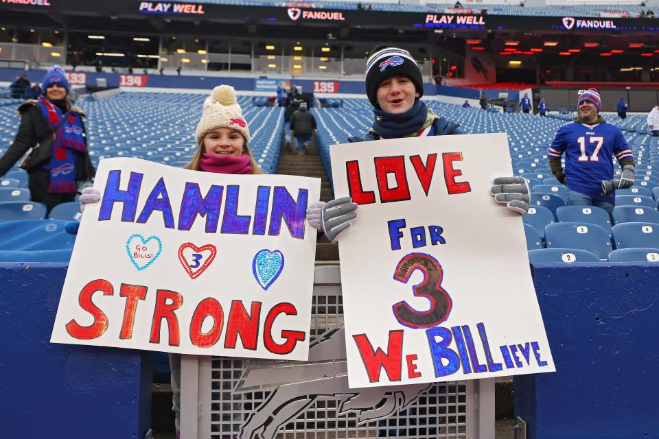 Buffalo Bills fans hold signs in support of Buffalo Bills safety Damar Hamlin.