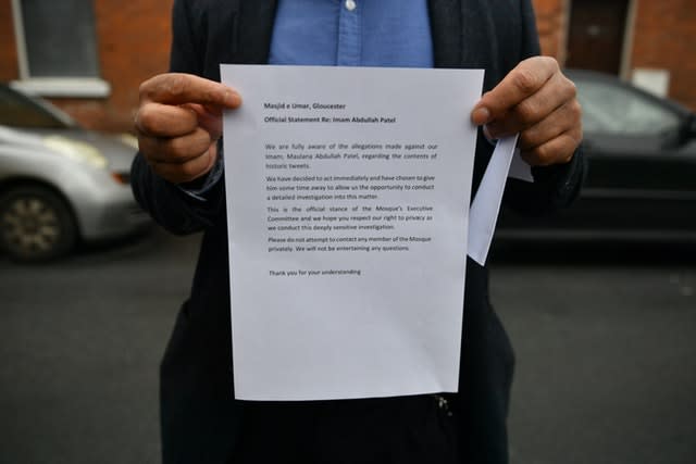 A member of the Masjid e Umar mosque in Gloucester, where Abdullah Patel is imam holds a statement outside the mosque (Ben Birchall/PA)