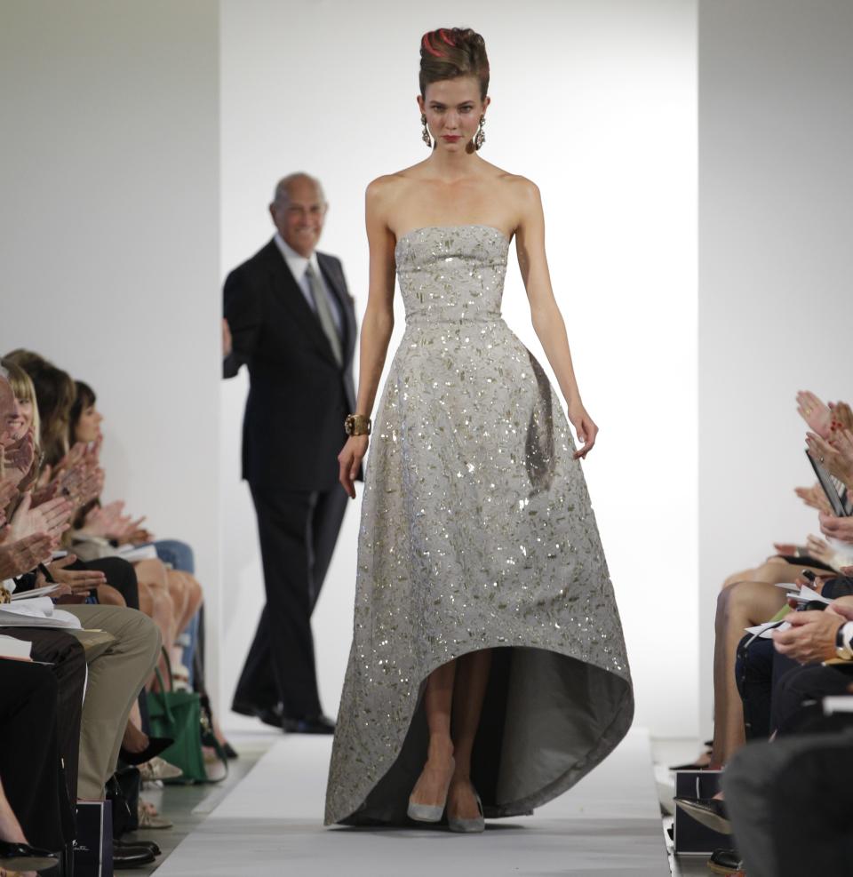 Fashion designer Oscar de la Renta watches as the final model walks the runway during the presentation of his Spring 2013 collection at Fashion Week in New York, Tuesday, Sept. 11, 2012. (AP Photo/Kathy Willens)