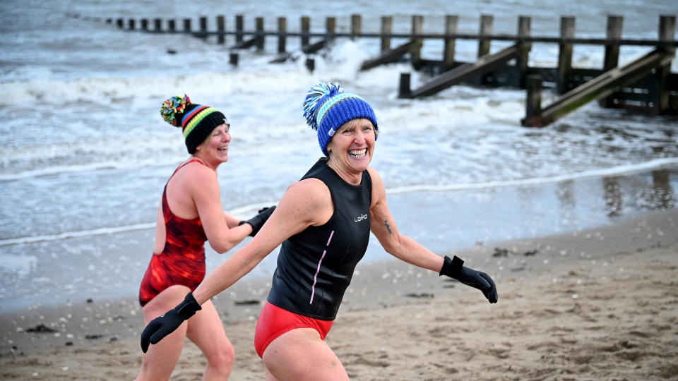 Two women wild swimmers go for a swim at Portobello beach in the snow, Scotland.