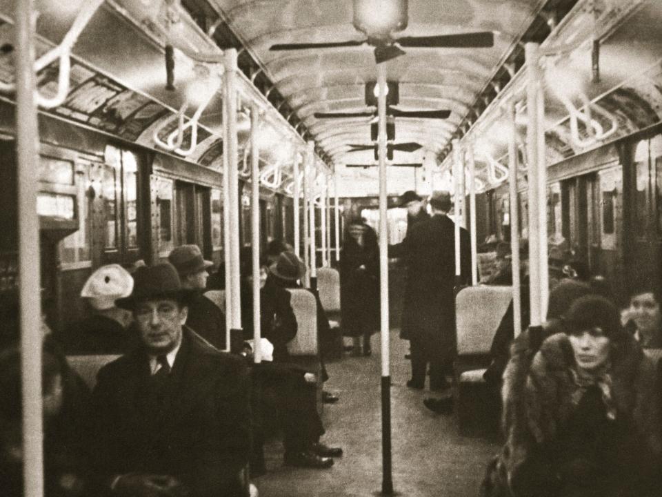 Interior of an Eighth Avenue subway carriage full of people in the early 1930s.