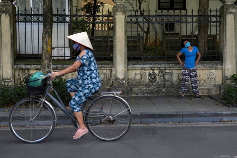 FILE PHOTO: A woman wears a protective mask as she exercises on the street amid COVID-19 pandemic, in Hanoi